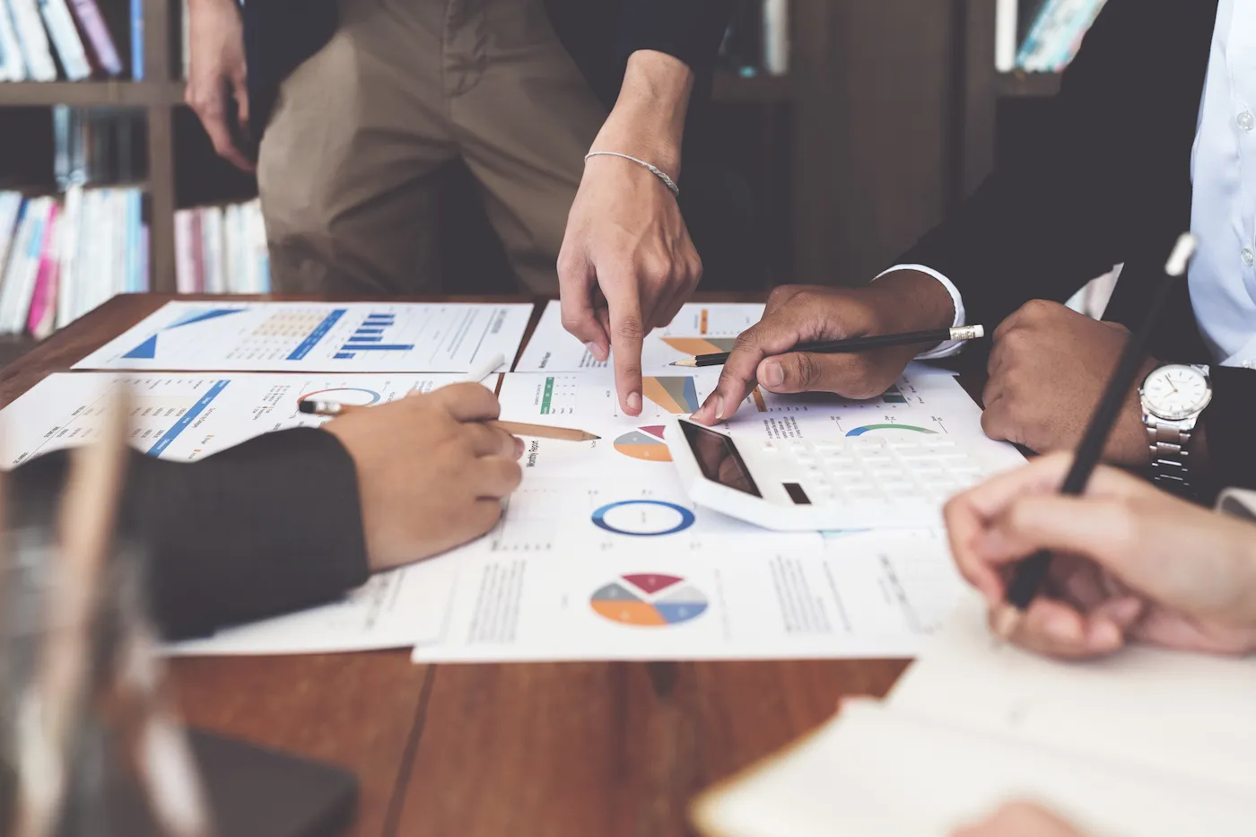 A group of financial planners working together on papers on a desk.