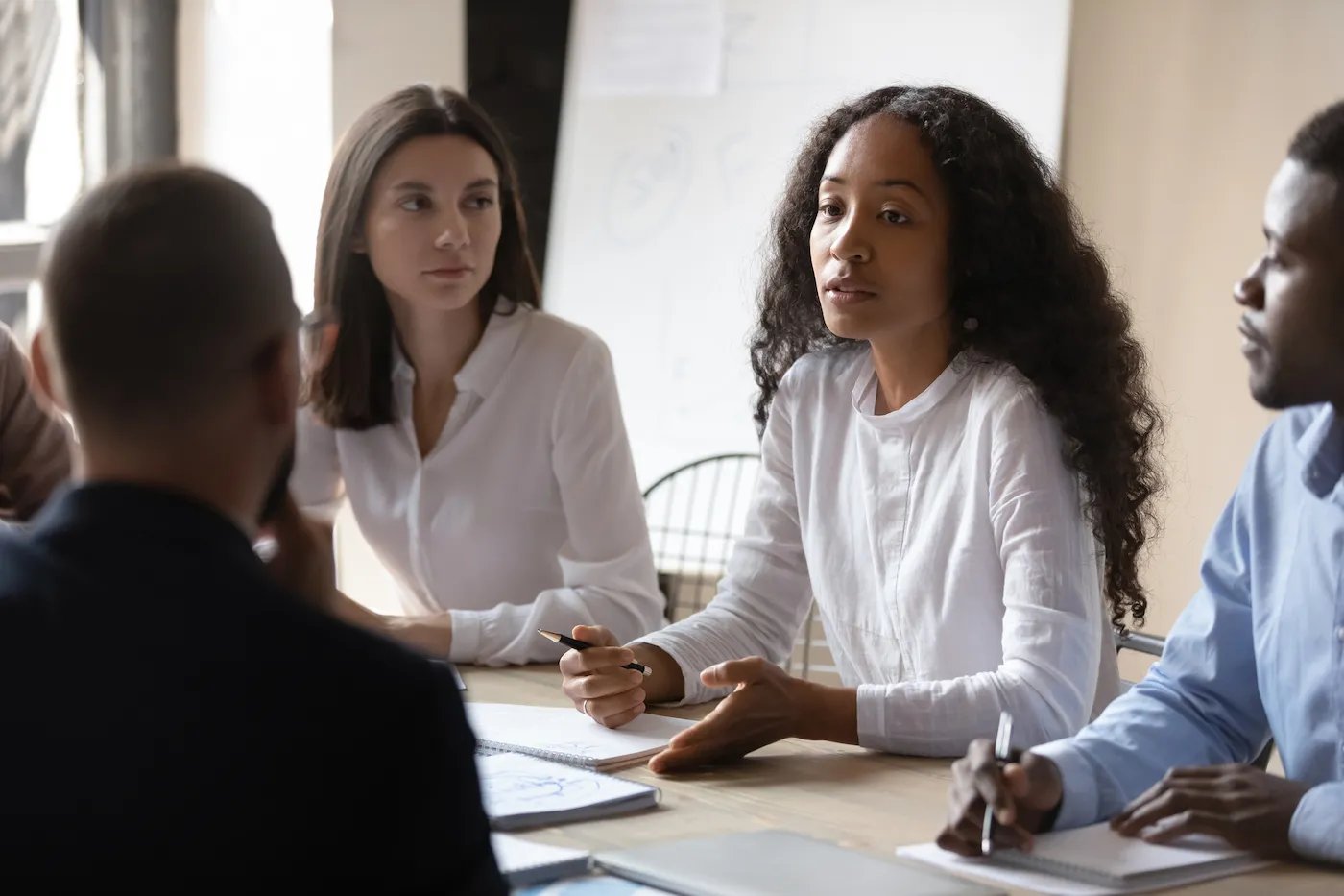 A diverse financial team brainstorming inclusion efforts at a table