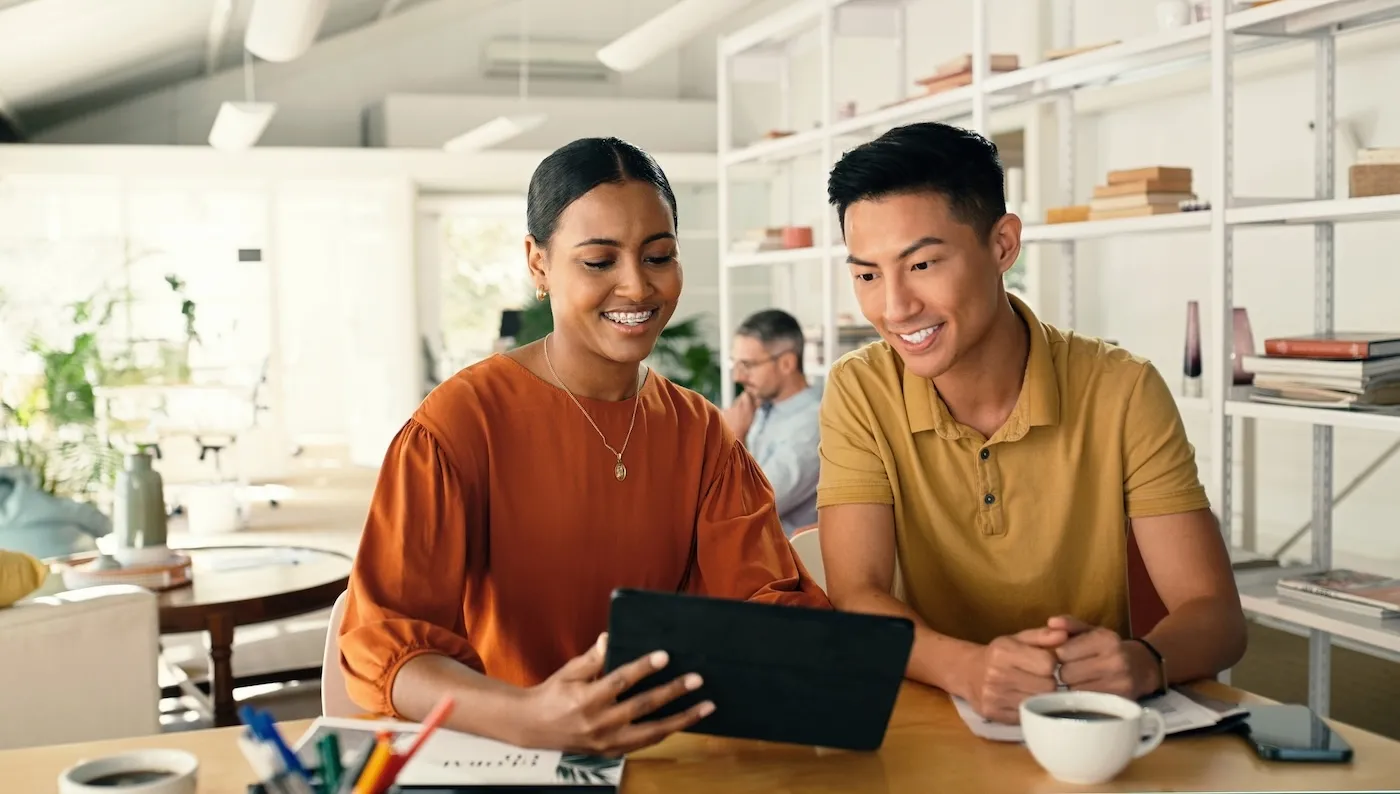 Woman talking to business partner about investing while holding a tablet.