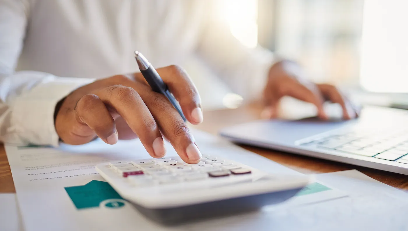 Shot of a person's hands calculating their debt.