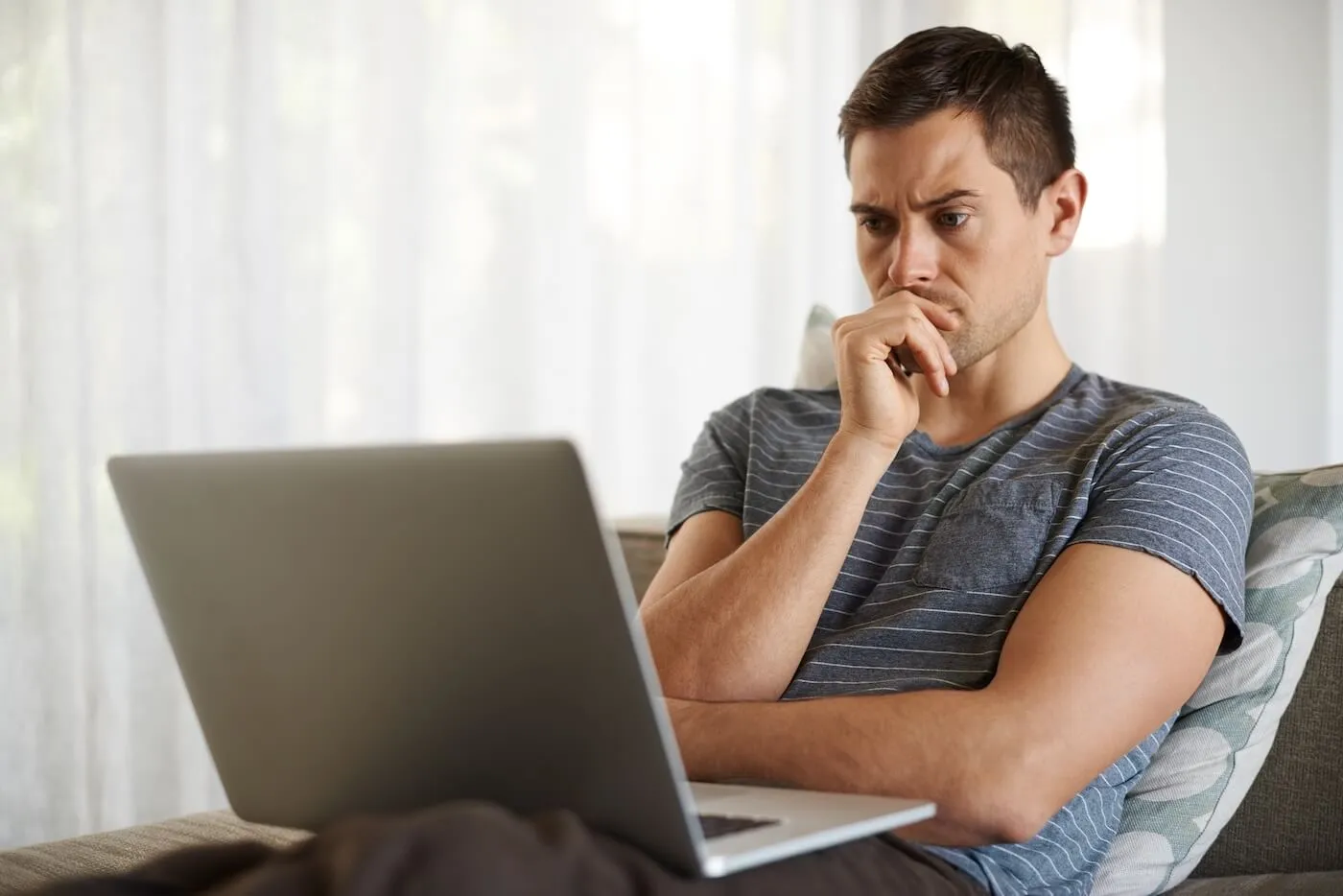 Concerned man looking at the laptop monitor