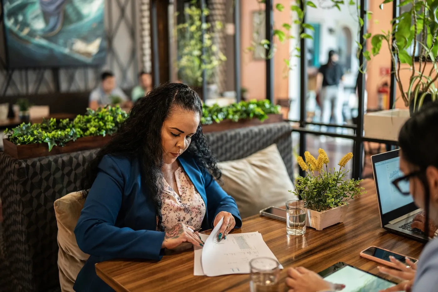 A woman analyzing papers at a restaurant.