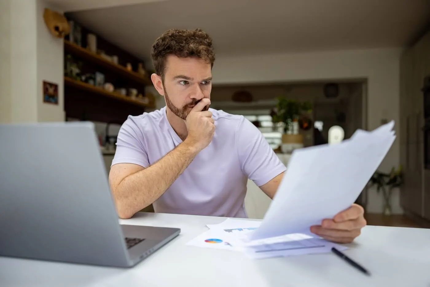 Concerned man reviewing bills in a home office