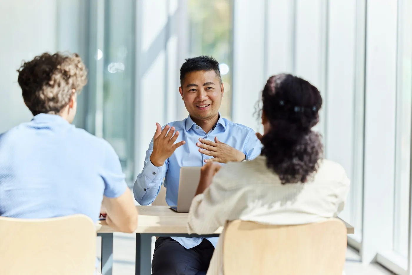 Happy insurance agent communicating with a couple during a meeting in the office.