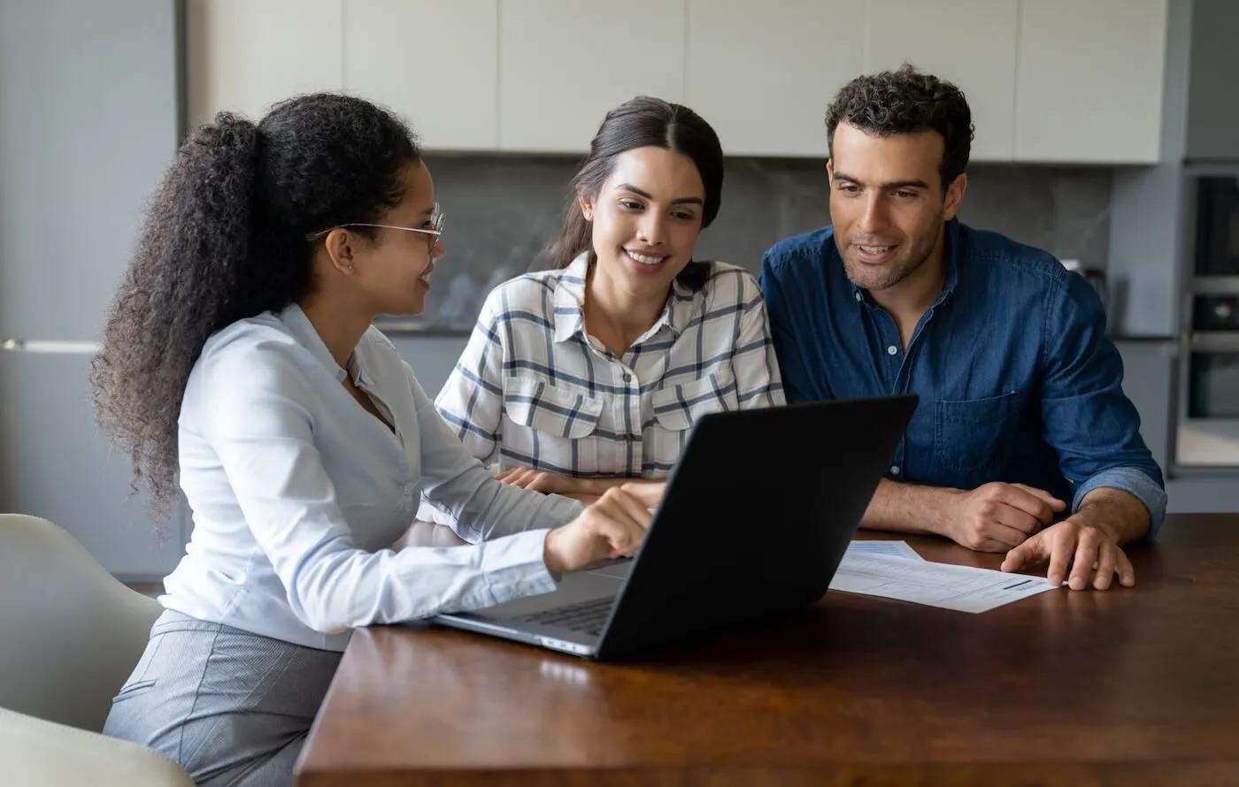 A young couple in the living room talking to an agent about the home loan