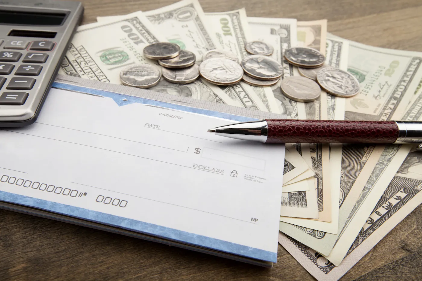 Checkbook, Pen, Calculator and Money - Close Up