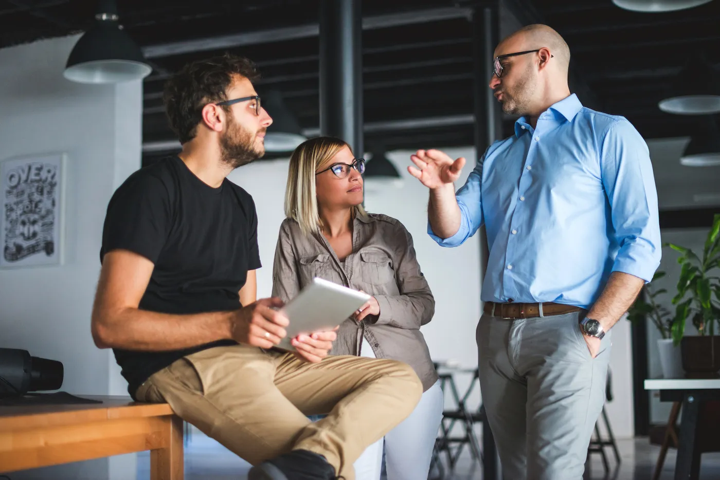 Three coworkers discussing how to invest in peer-to-peer lending.