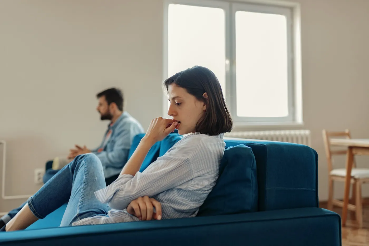 An unhappy couple stressing about finances in the living room.