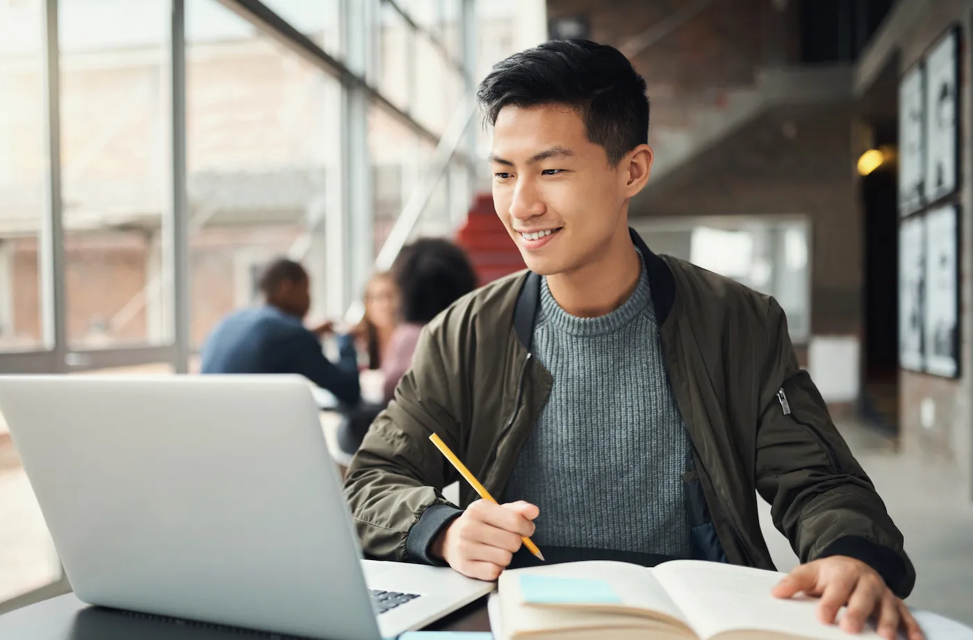 A student working and opening a student checking account on a laptop.