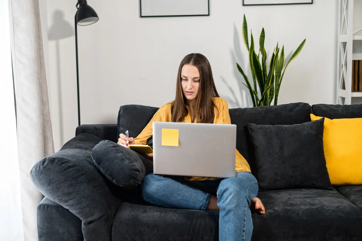 Focused woman working with a laptop at home.