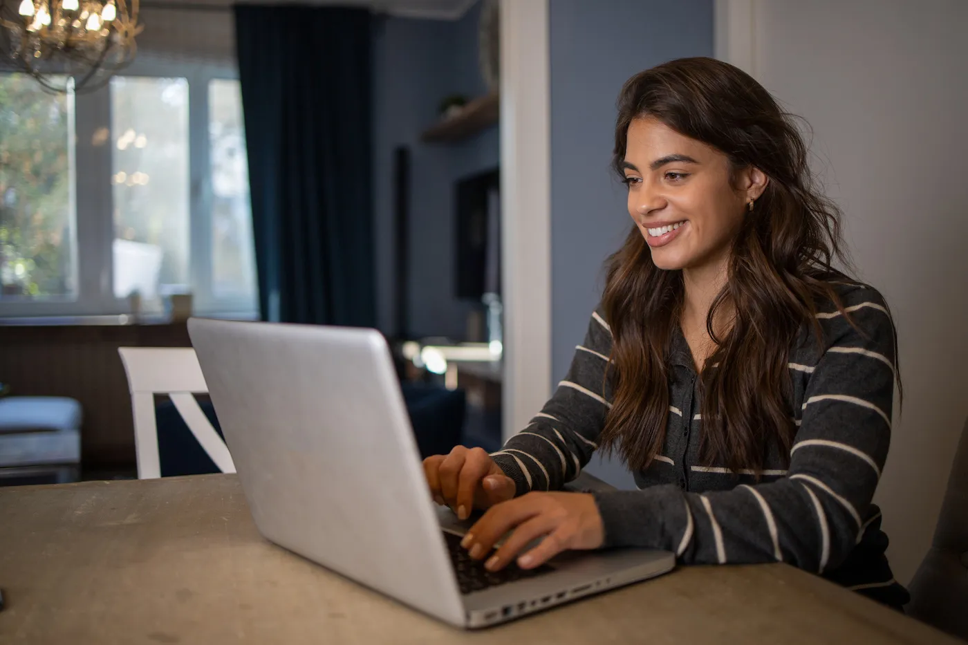 Woman working on personal finances using a laptop at home.