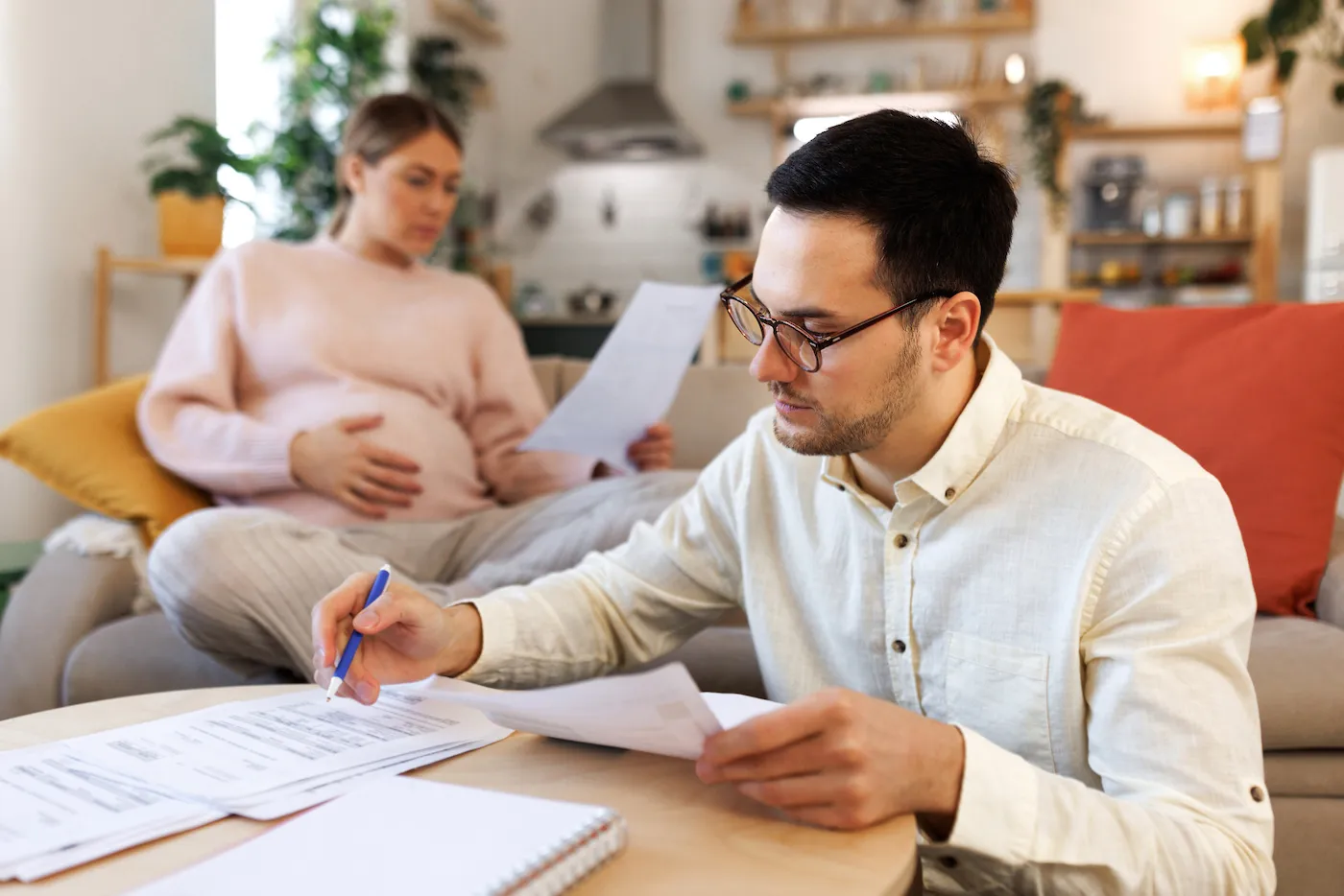 Couple sitting in their living room and checking their finances.