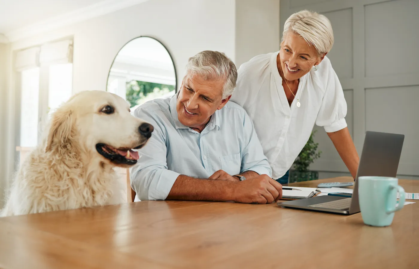 Happy couple in home with dog, saving money on pet insurance