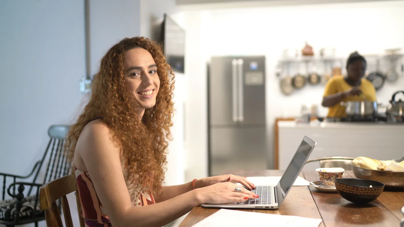 Portrait of a happy woman using laptop at home