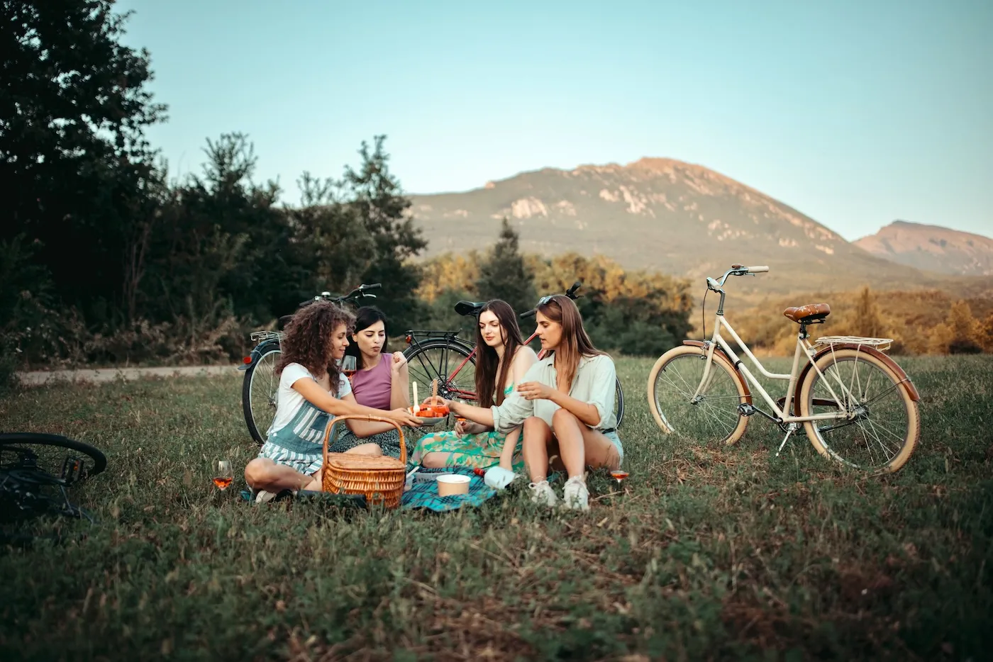 Group of carefree girls having a picnic on a beautiful day in the mountains.