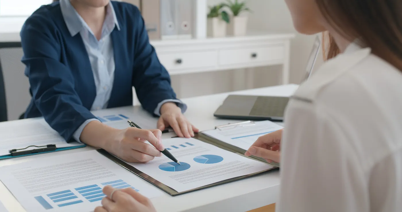 Insurance broker shows their client a breakdown of their quote on a desk