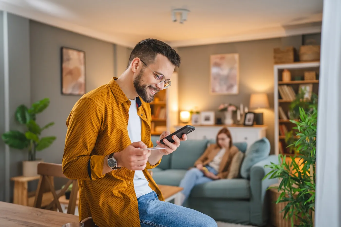 Adult man at home investing online using his mobile phone.