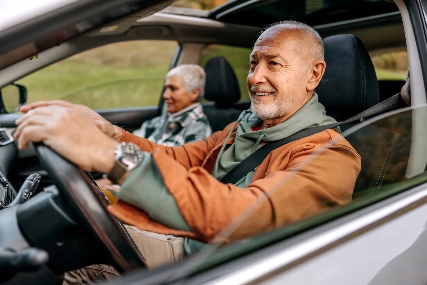 Smiling mature couple driving a car