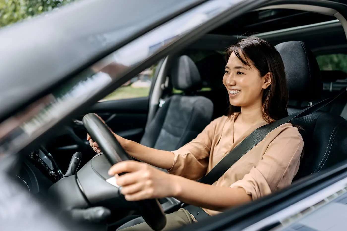 Smiling young woman driving a car