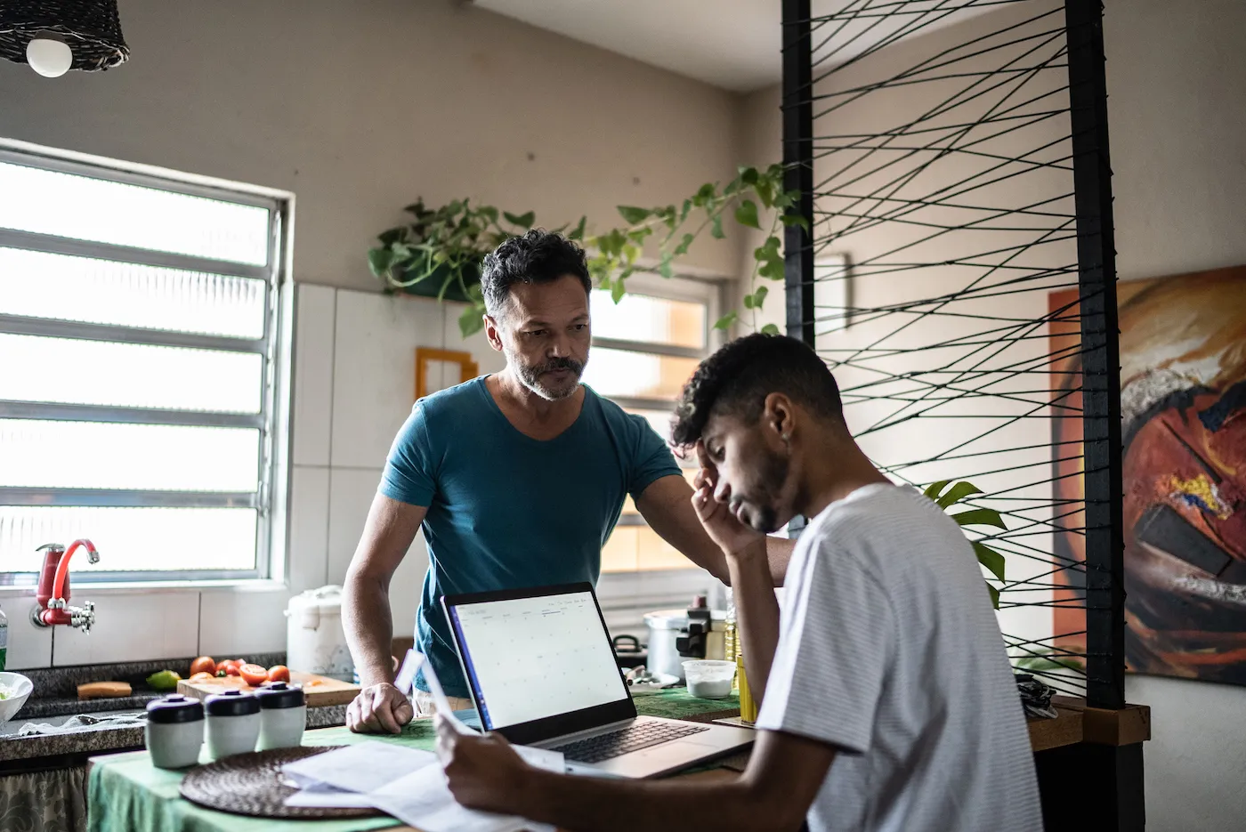 Worried man being supported by husband while paying off debt partially.