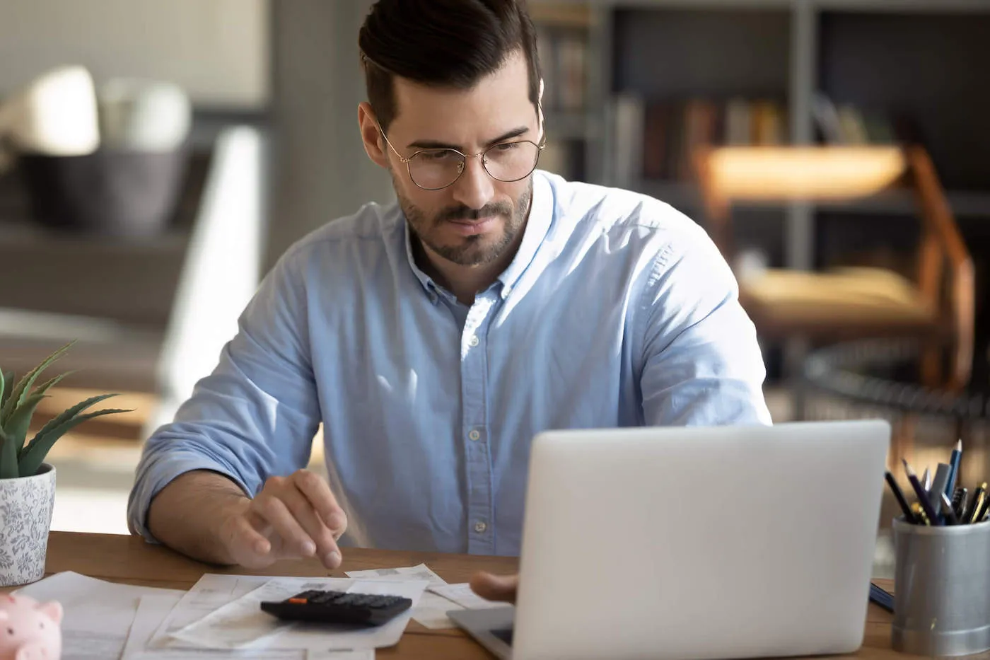 Man seated in home office budgeting.