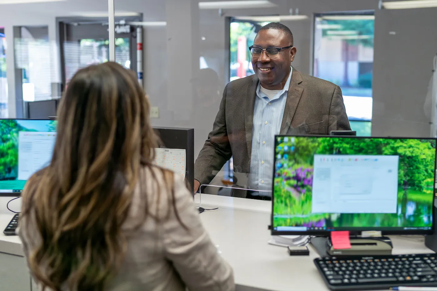 A man speaking to a bank teller to switch banks.