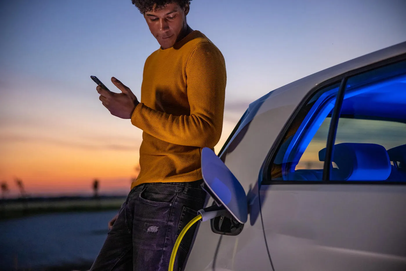 Man waiting for electric car to charge.