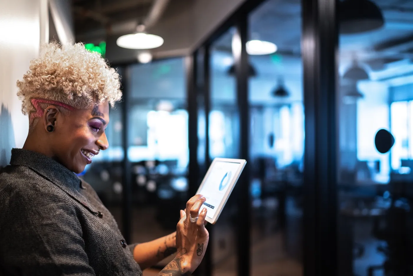 Happy woman using digital tablet for mobile banking in the office.