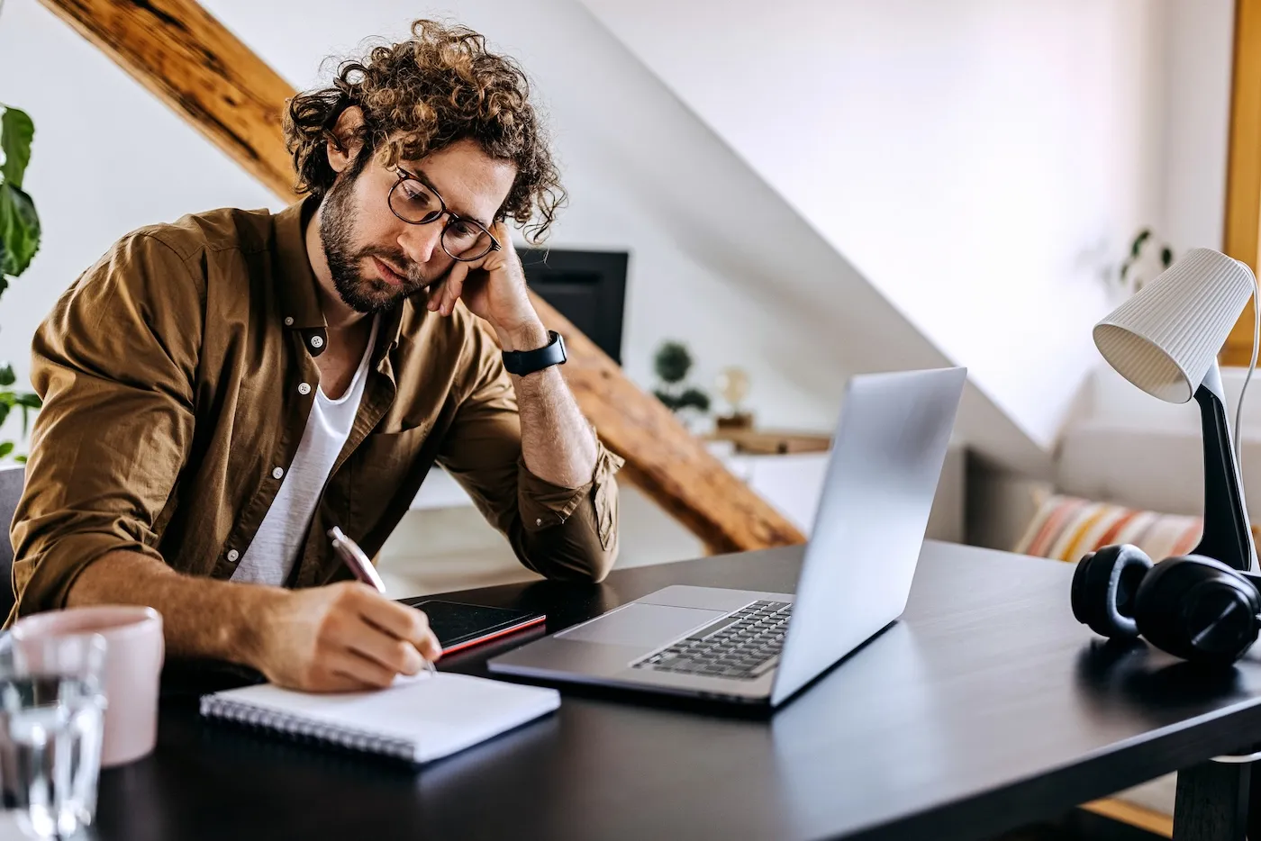 A man taking notes while working at home.