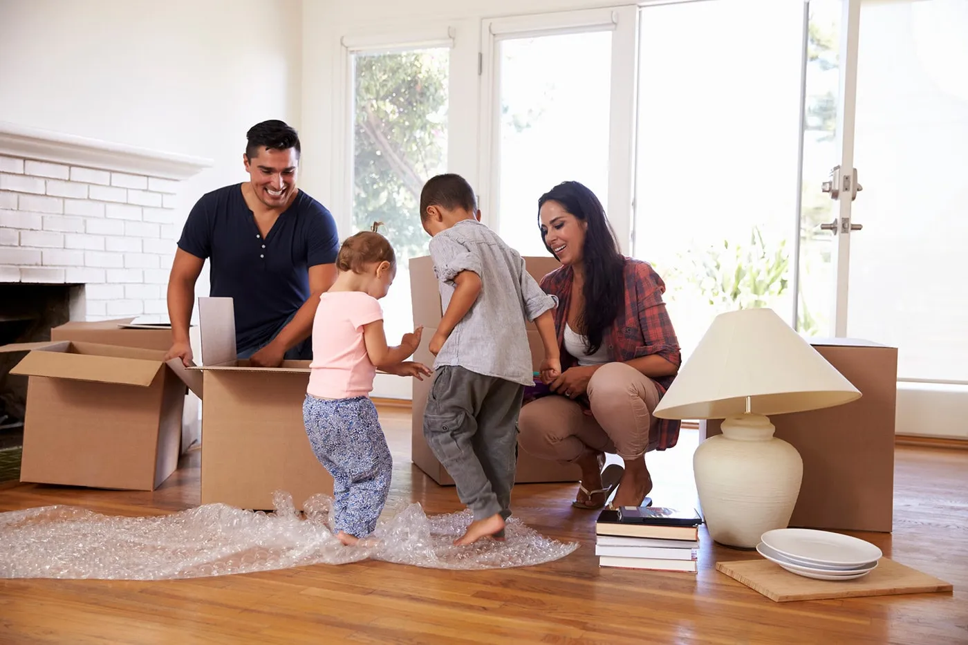 A family of four in their new home unpacking boxes.