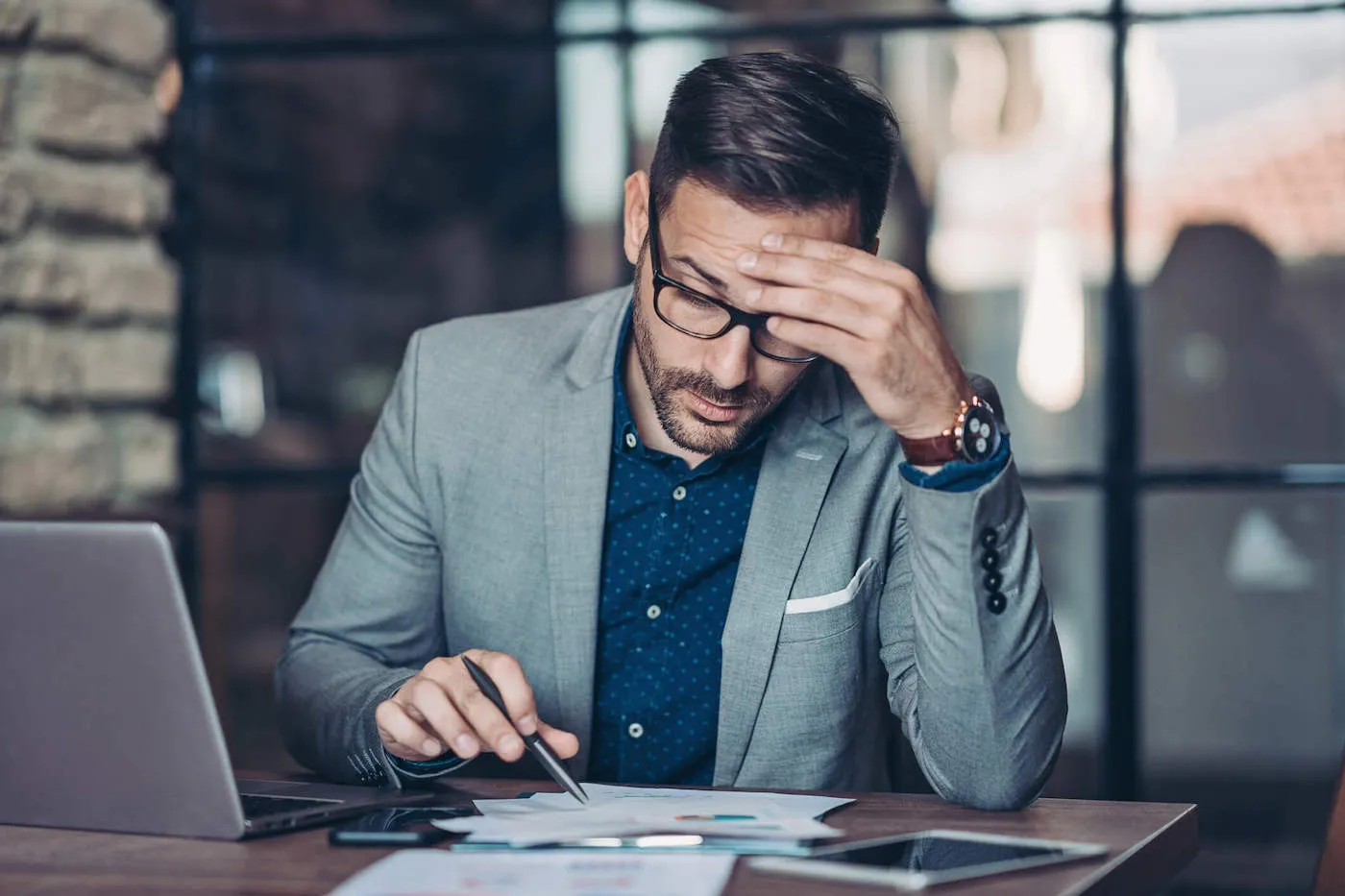 Nicely dressed man in suit filling out banking papers.