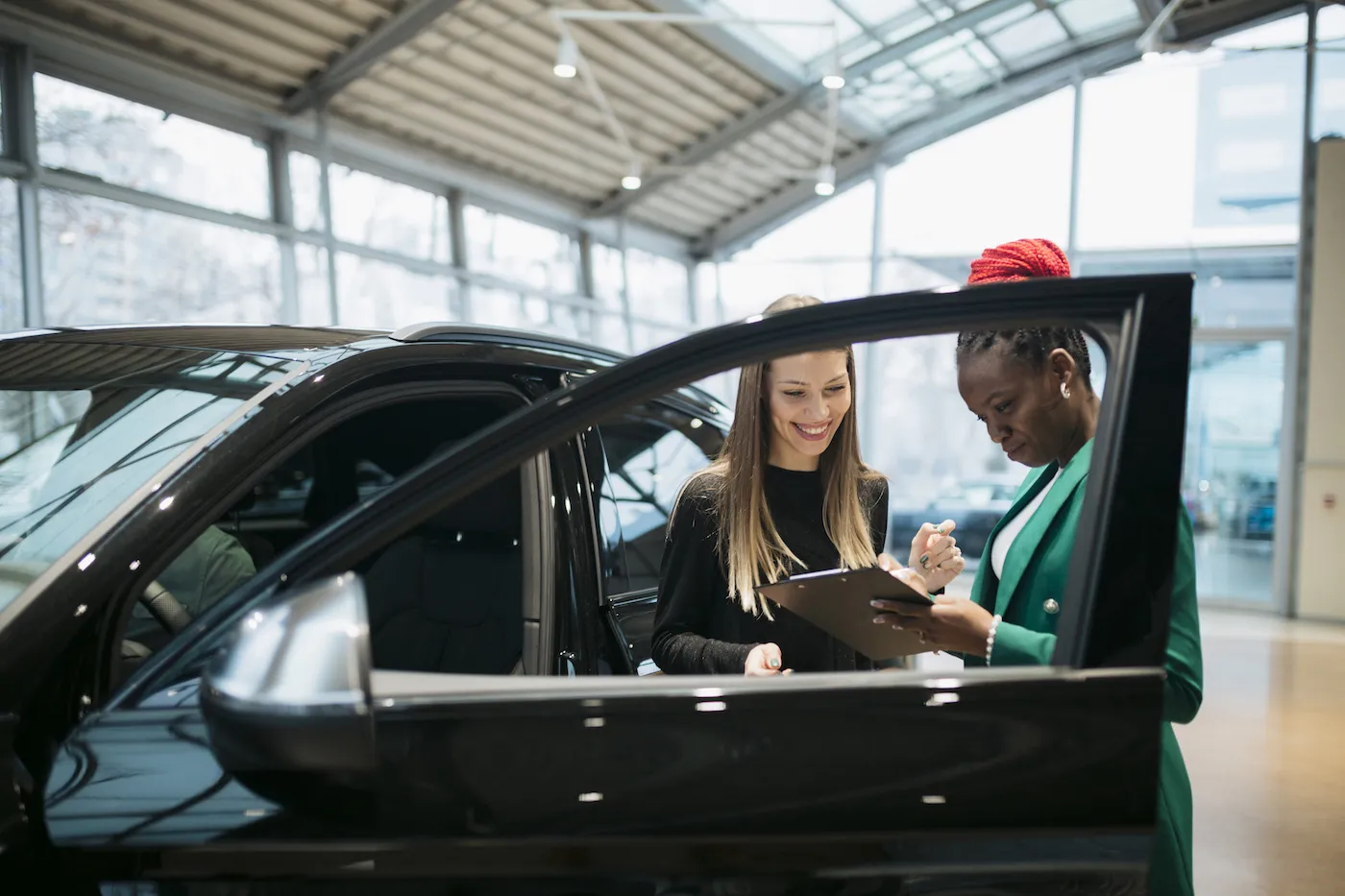 Saleswoman and a female customer in a car dealership