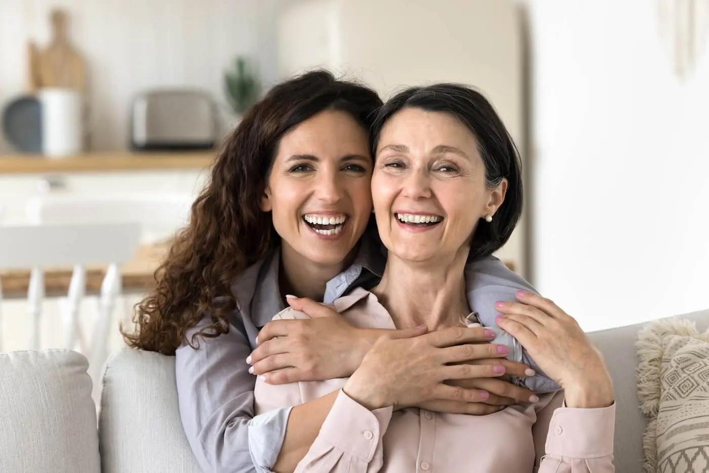 Smiling adult daughter hugging her mother