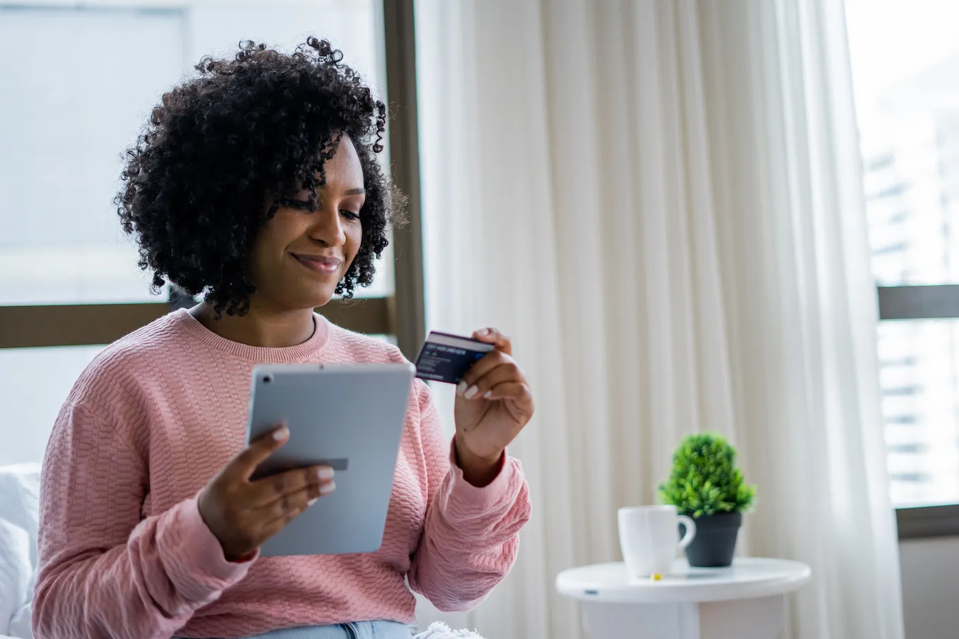 Woman paying utility bills with a credit card on her digital tablet.