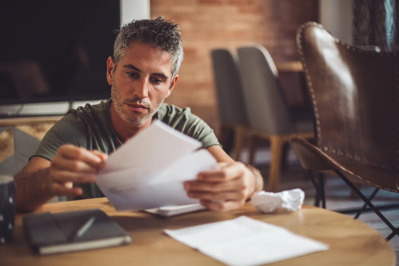 Man buying bonds, looking at financial documents in the mail.