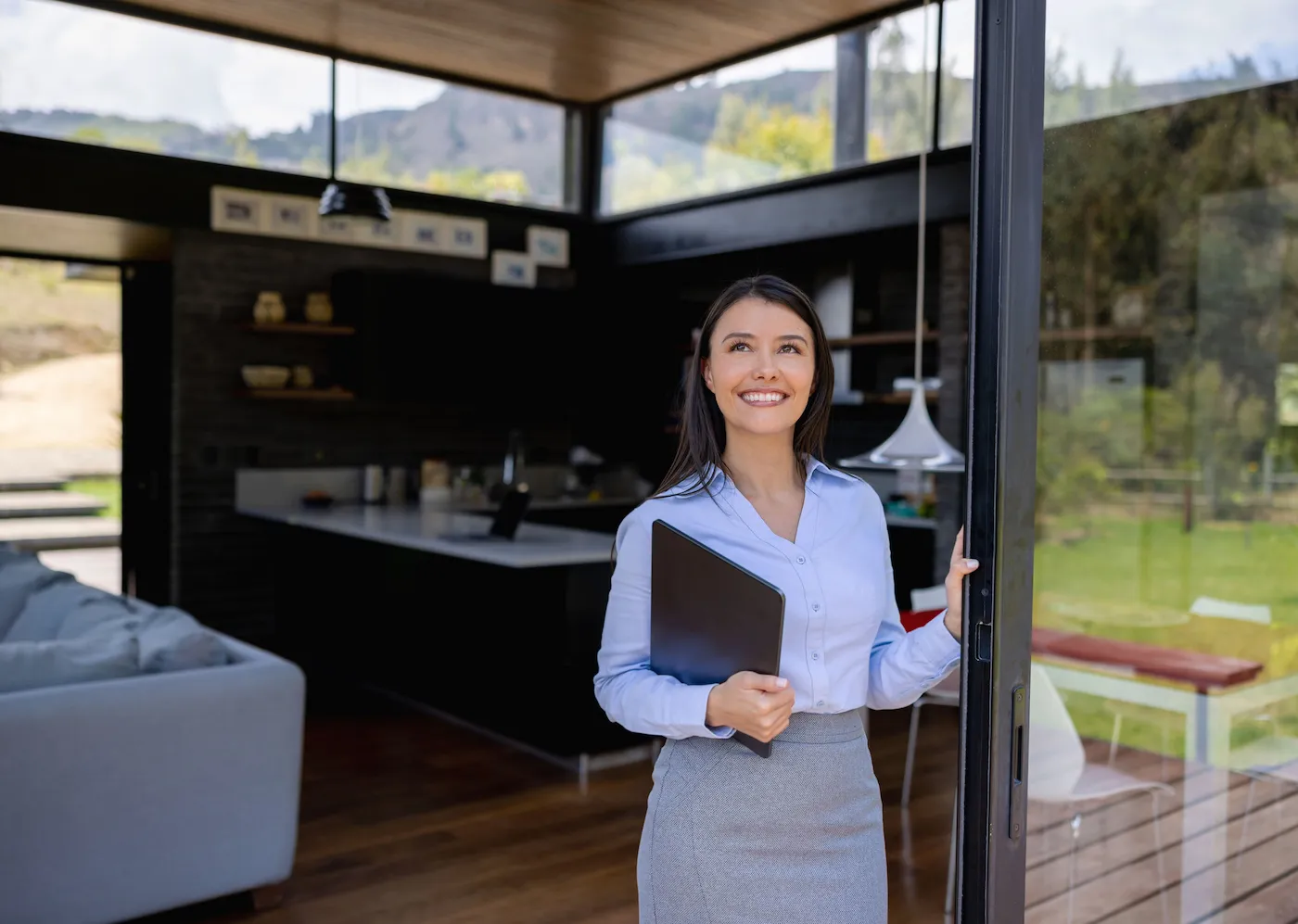 Happy real estate agent showing a property and smiling.