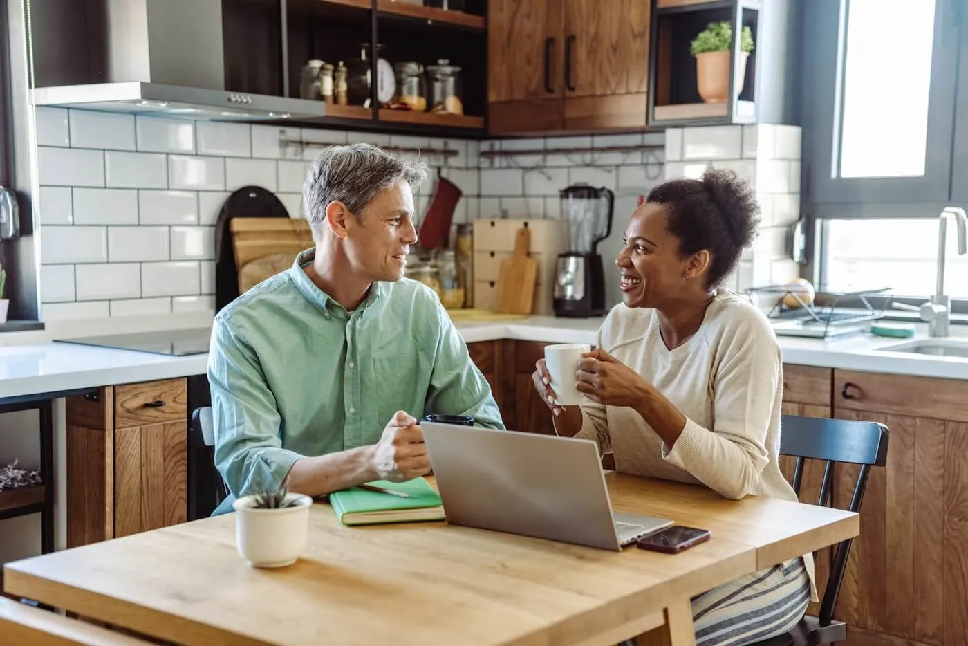 Mature couple using a laptop to review their retirement plans in the kitchen