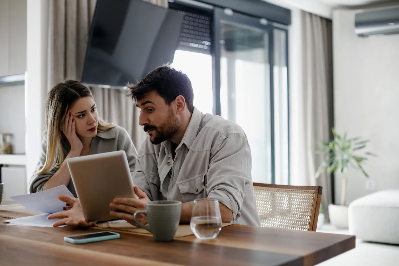 Serious couple analyzing the risks of not having homeowners insurance.