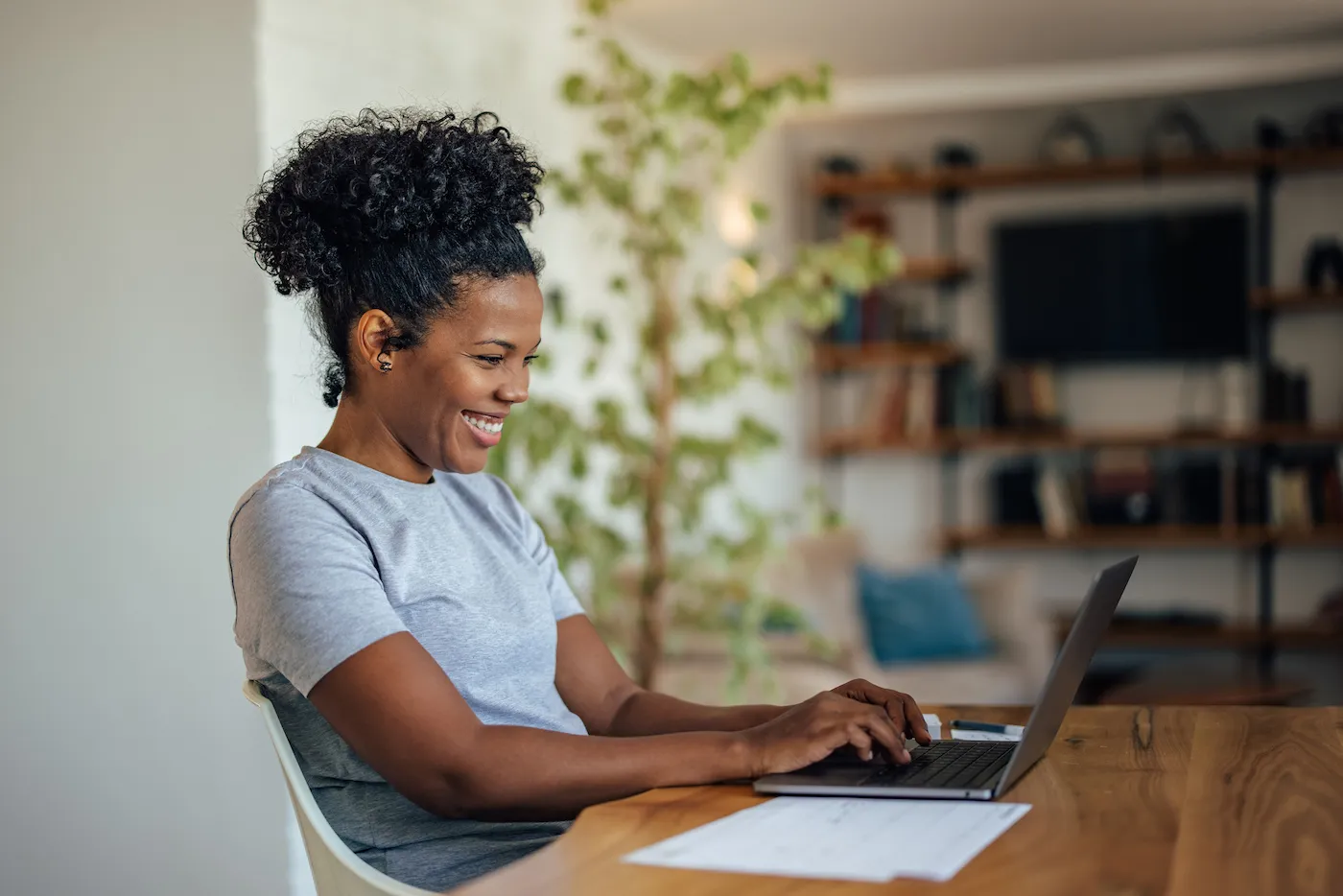 Happy woman, using her laptop, at home office. Saving for retirement.