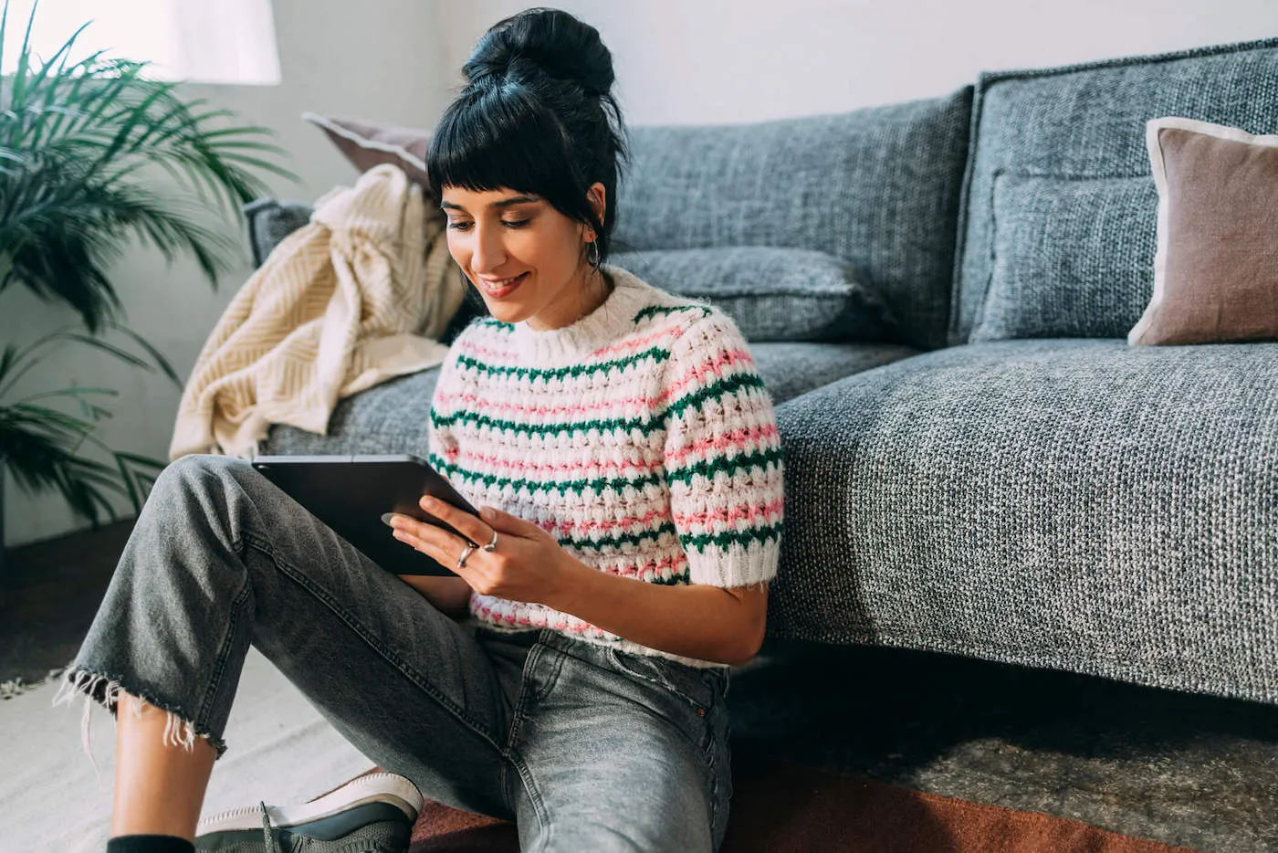 Seated woman banking online on tablet.