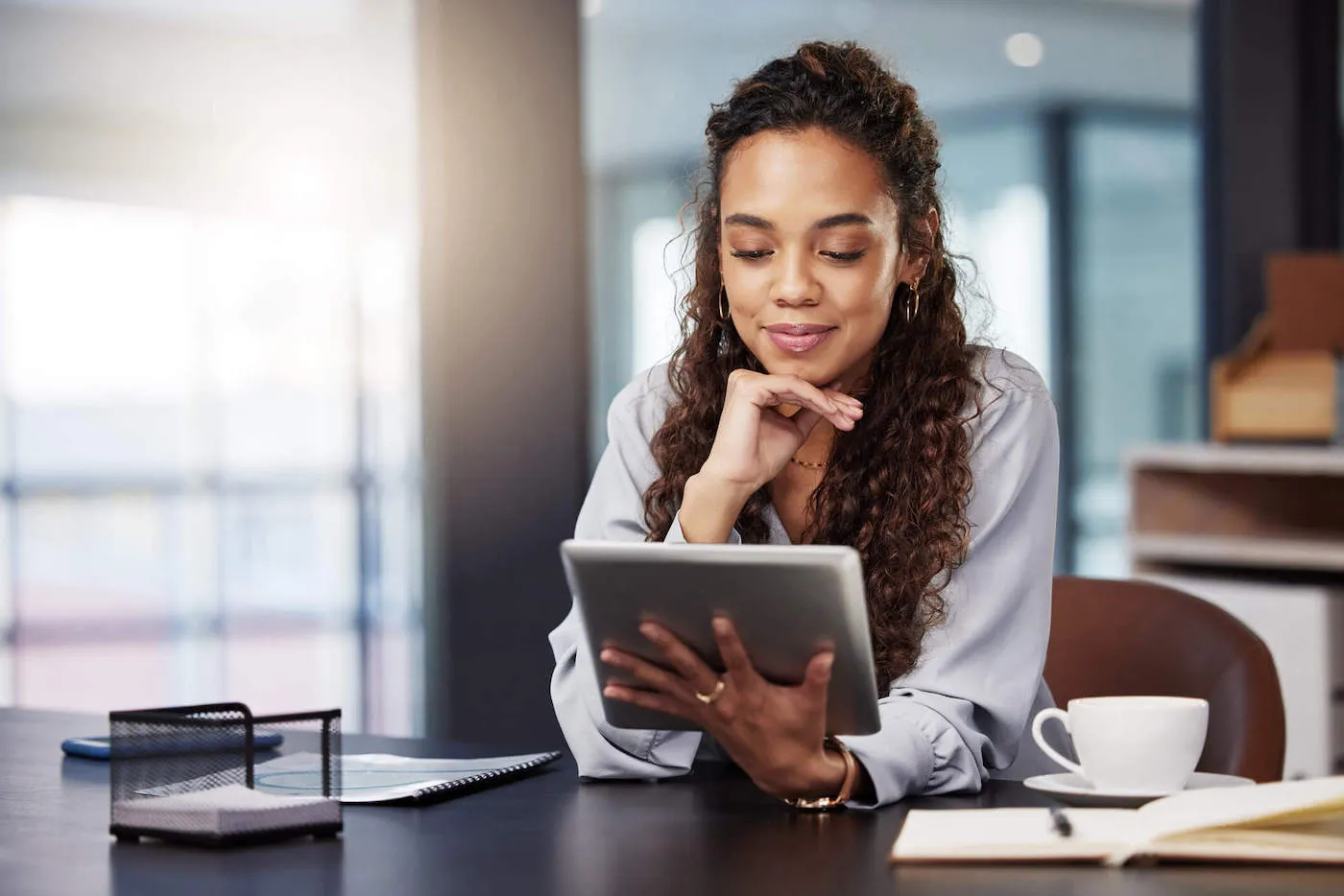 Seated woman reading on tablet.