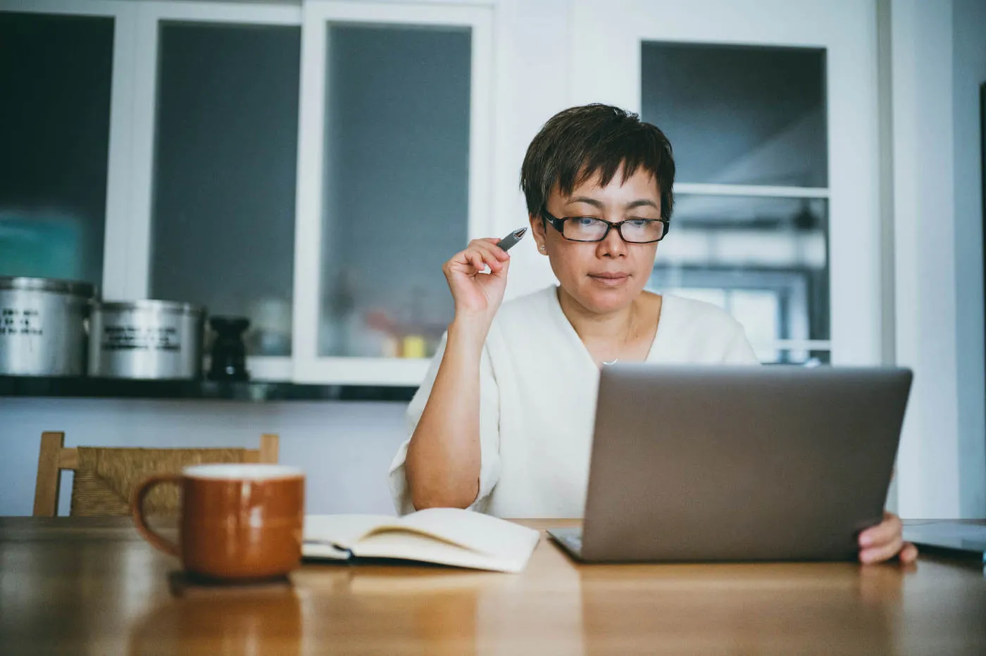 Seated woman researching online how much cash to keep at home.