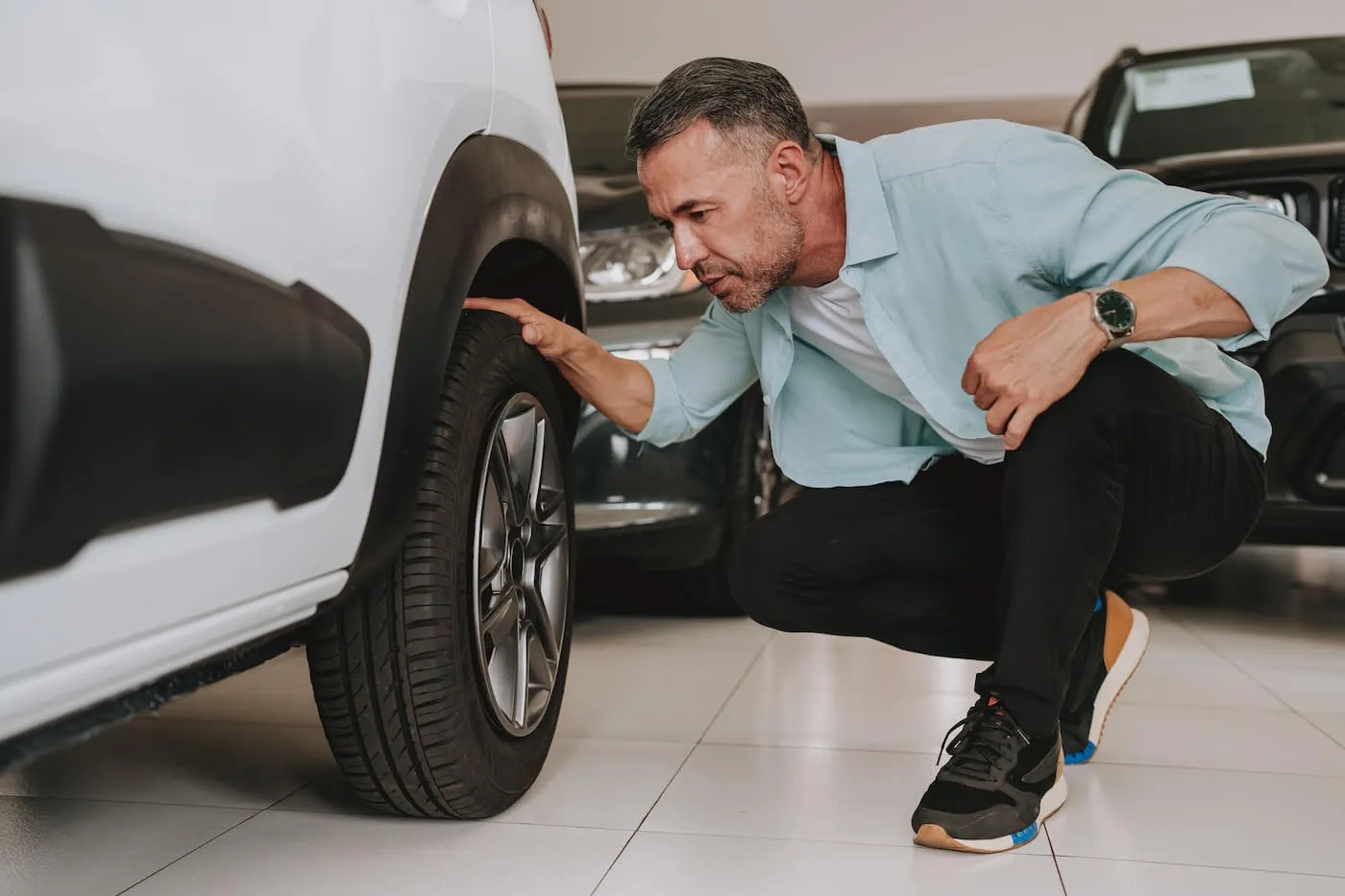 Mature man inspecting a salvage title car before buying