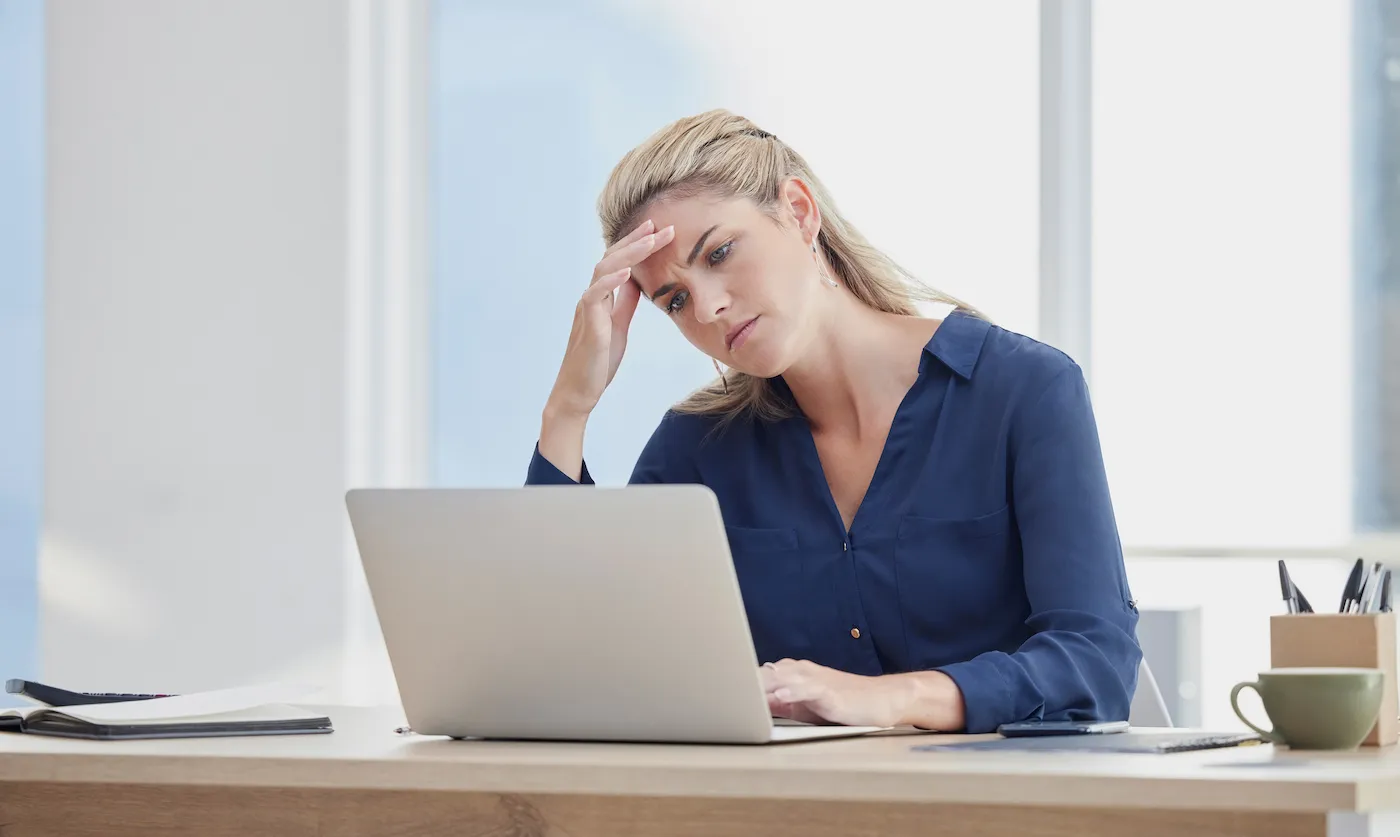 A woman researching investing her emergency fund using her laptop.