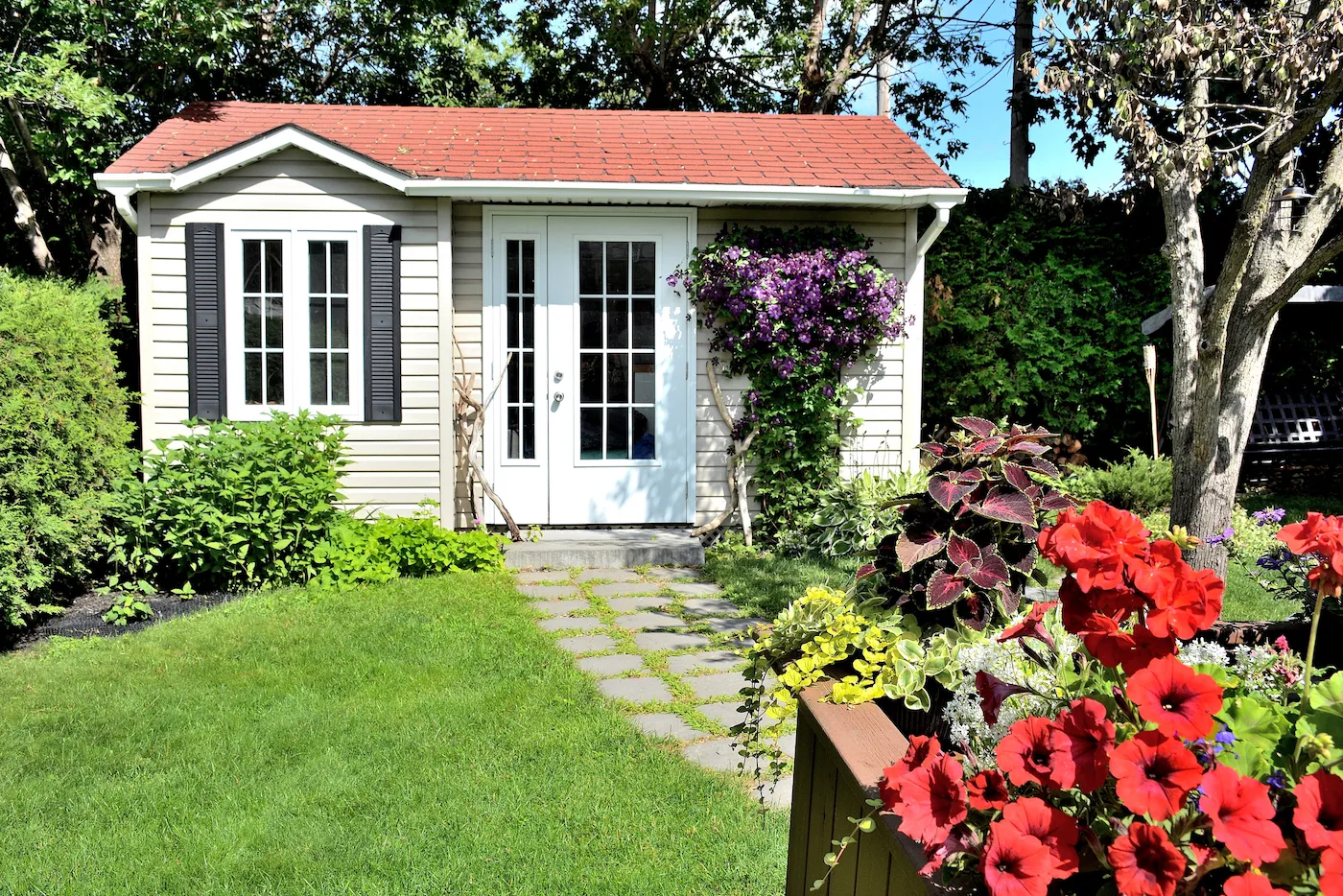 Small house in backyard with lawn and stone path