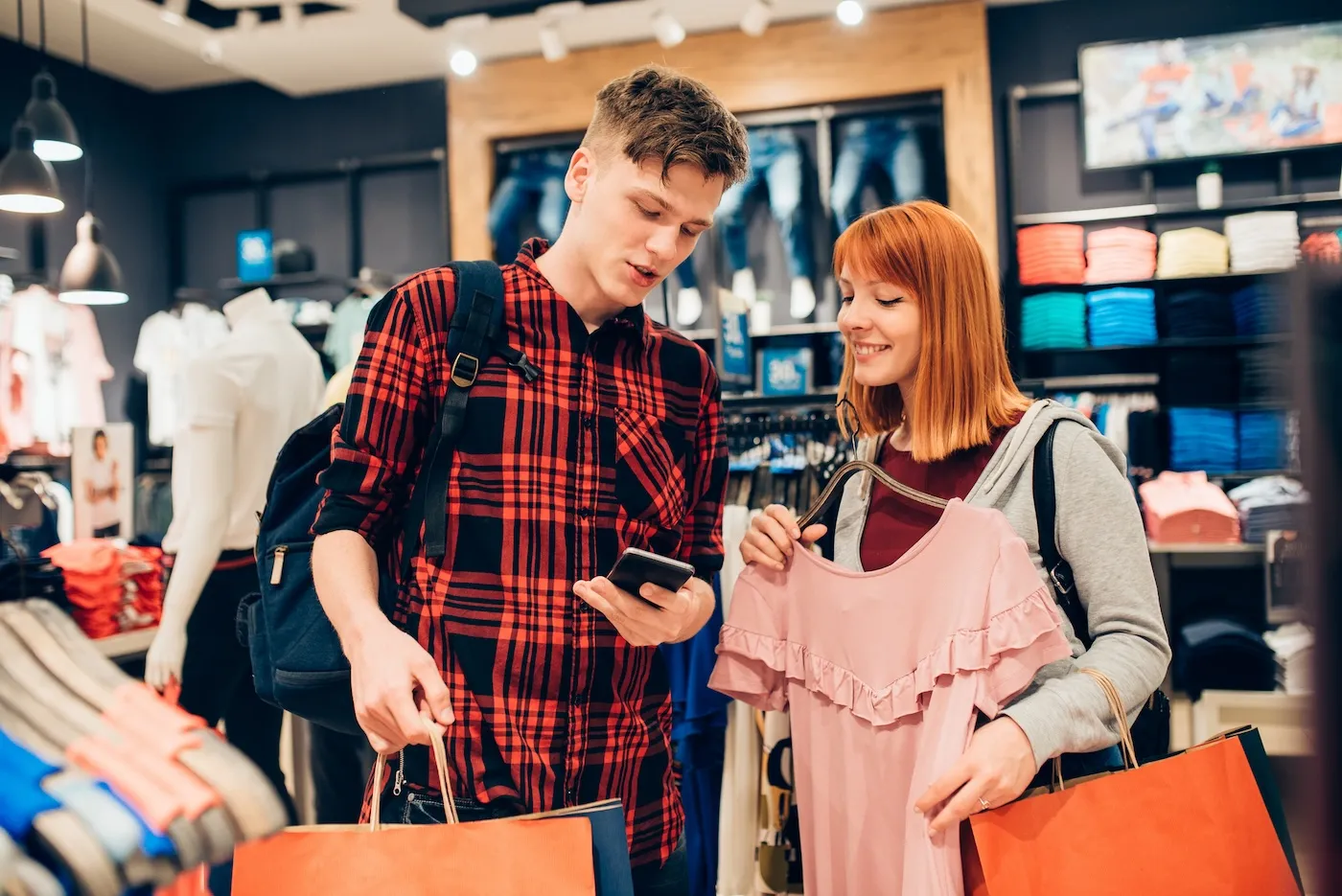 Cheerful teenagers spending money at the shopping mall.