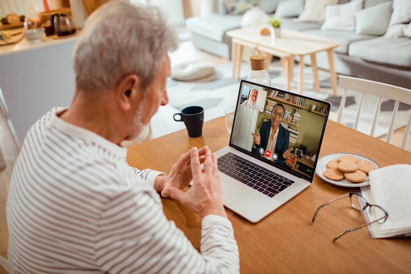 Close up of a senior man talking to his stockbroker over a video call