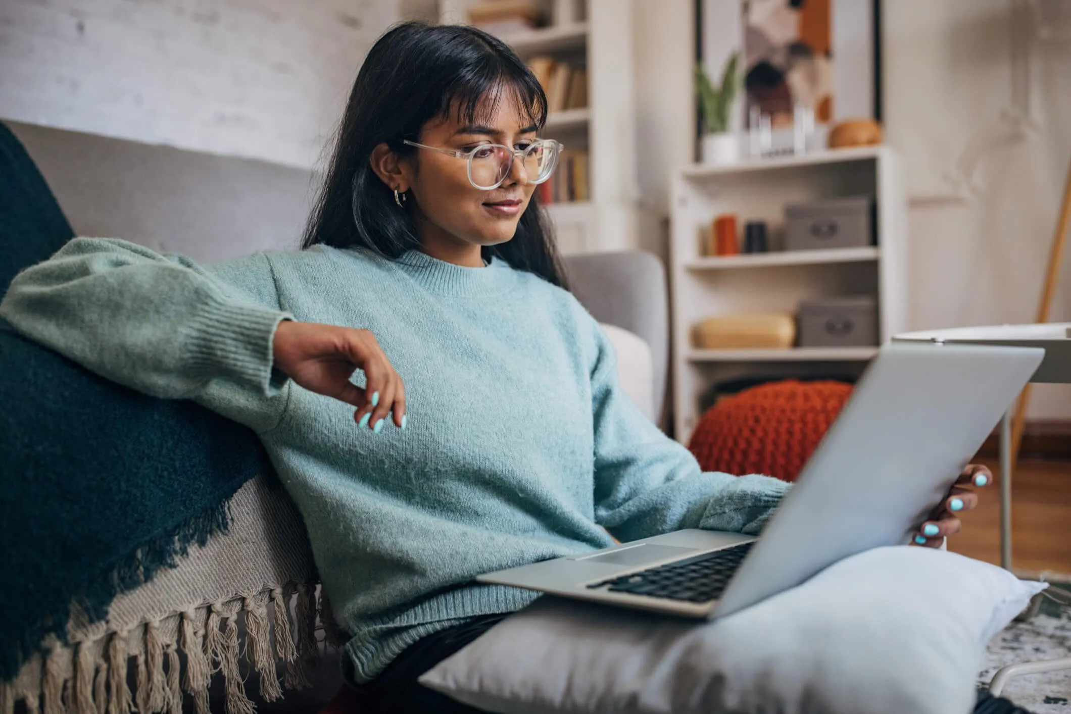 Young woman using a laptop while sitting on a couch