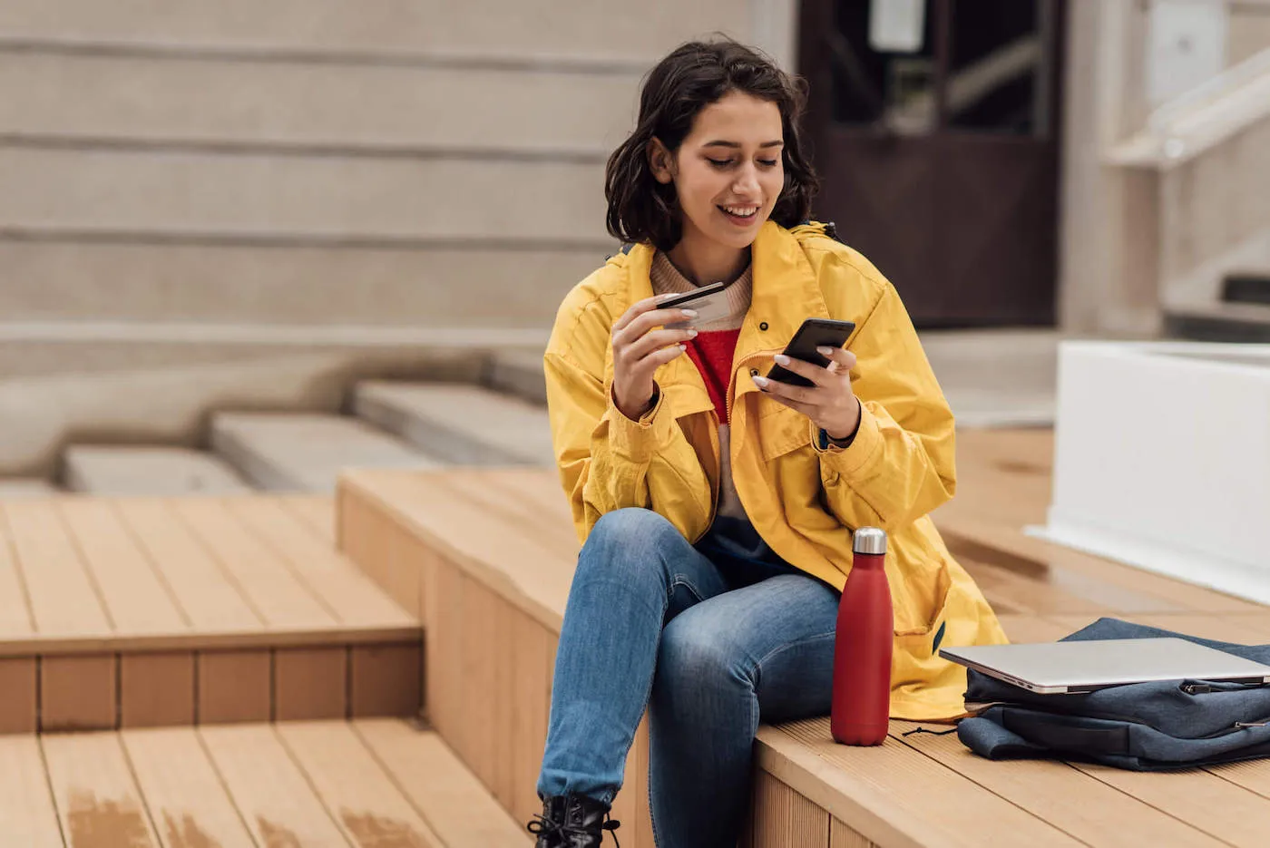 Student shopping online in front of her college.