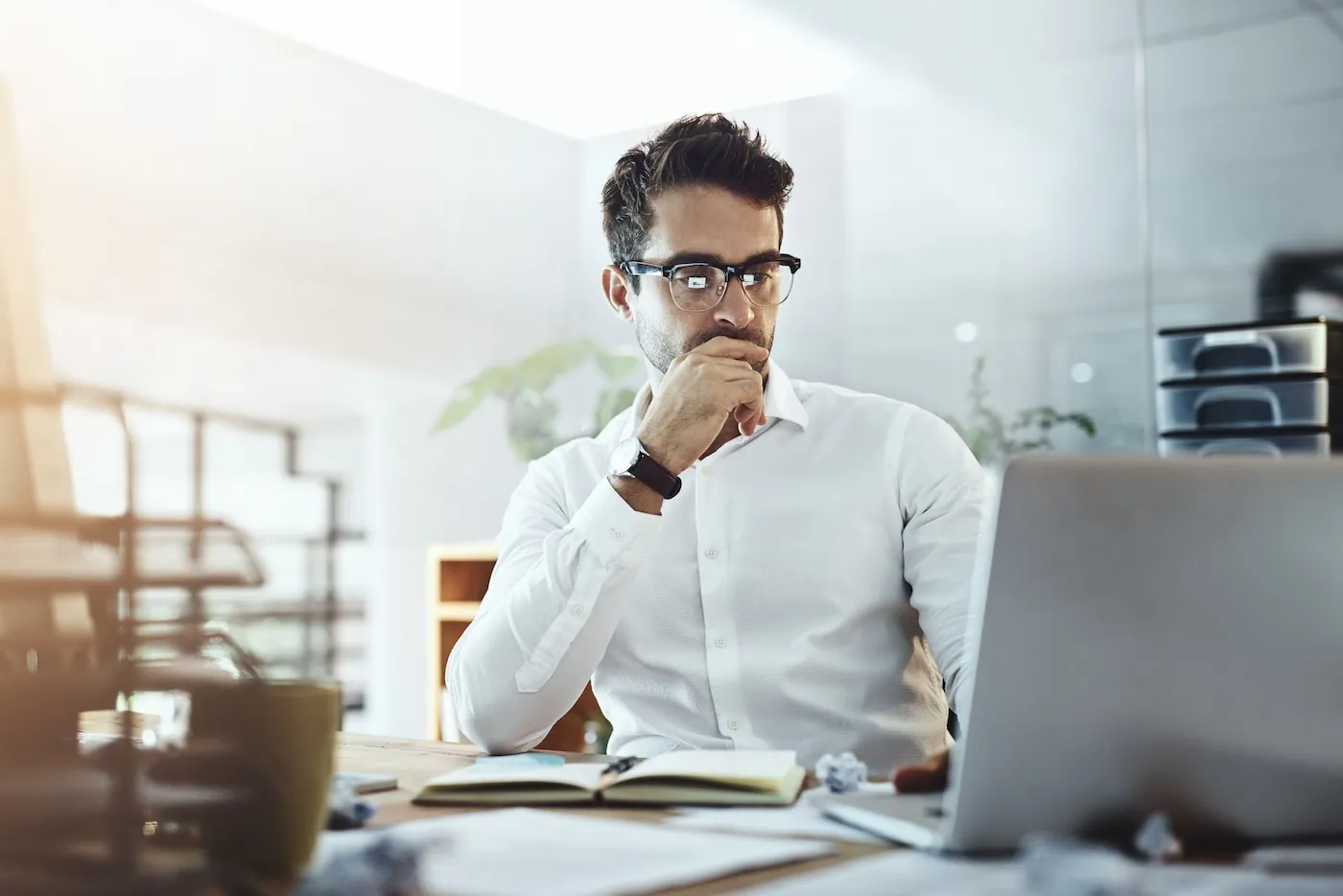 Shot of a young businessman working in an office, trying to get a mortgage.